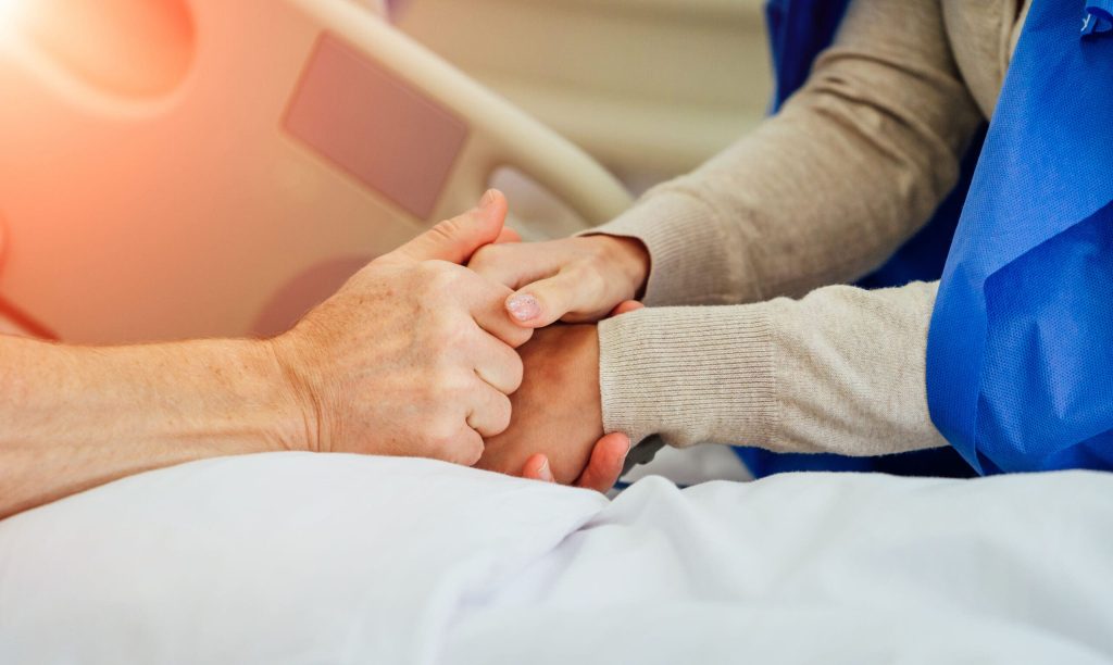 Personas tomándose de la mano en un hospital